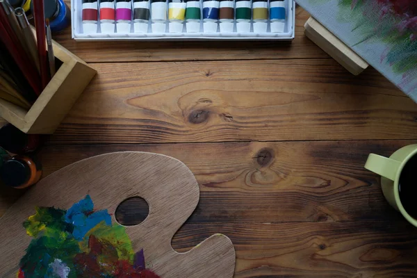 木制桌子上的顶视图画笔 水彩画 调色板和咖啡杯 — 图库照片