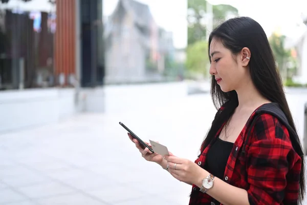 用智能手机和信用卡上网购物的年轻亚洲女人 — 图库照片