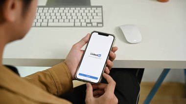 CHIANG MAI, THAILAND: 28 Ağustos 2021: LinkedIn uygulaması ile akıllı telefonu ekranda tutan adam. LinkedIn, iş bağlantılarının aranması ve kurulması için bir sosyal ağdır..