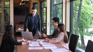 Modern konferans odasında iş arkadaşları için yakışıklı iş adamı sunumu finansal bilgiler.