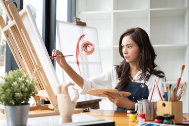Sanat stüdyosunda resim yapan güzel Asyalı kadın ressam..