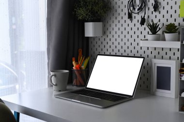 Bilgisayarlı ofis masası, kahve fincanı ve fotoğraf çerçevesi..