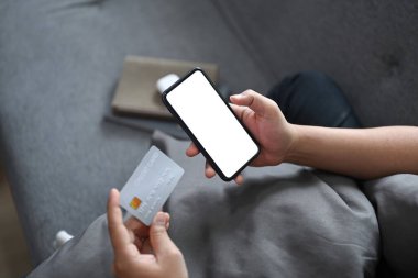 Kanepede oturup internetten alışveriş yapan ya da akıllı telefonuyla internetten yemek yapan genç adamı kapat..