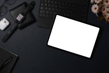 Dijital tabletin üstünde, siyah deri üzerinde akıllı saat ve cüzdan.
