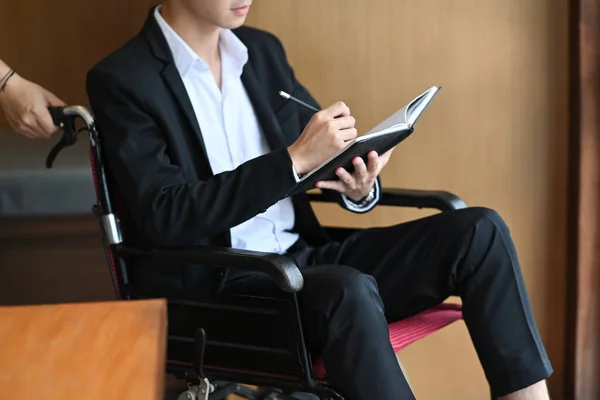 Інвалідний Бізнесмен Інвалідному Візку Тримає Ручку Пише Деяку Інформацію Блокноті — стокове фото