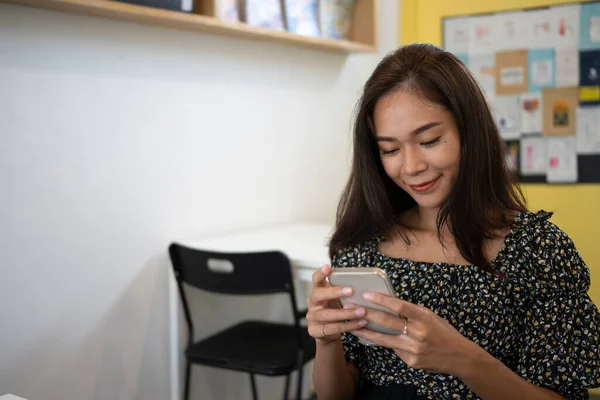 Kahve Dükkanında Cep Telefonu Kullanan Gülümseyen Bir Kadın — Stok fotoğraf
