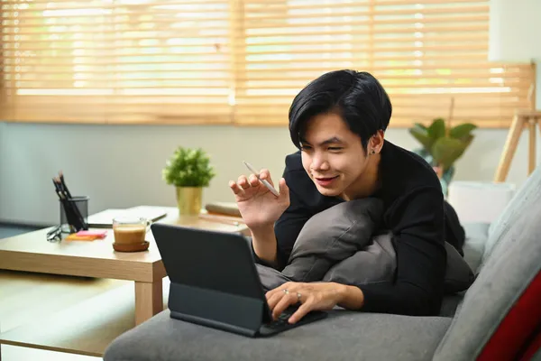 Fiatal Ázsiai Férfi Miután Videohívás Számítógép Tabletta Kanapén — Stock Fotó