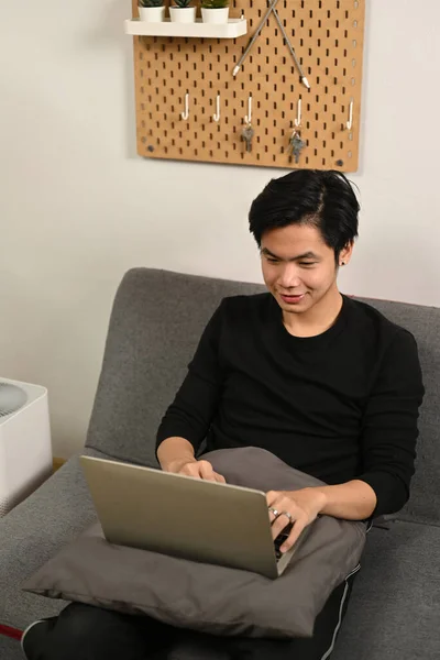 Azji Człowiek Siedzi Kanapie Przeglądanie Internetu Laptopa — Zdjęcie stockowe