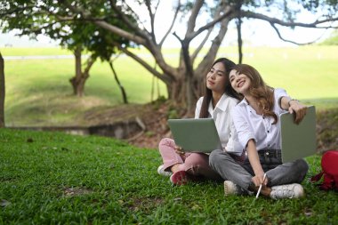 Parkta birlikte çalışan iki Asyalı kadın..