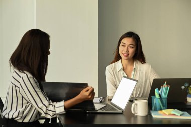 Ofiste birlikte çalışan gülümseyen iki kadın ofis çalışanı.. 