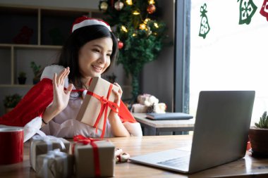 Dizüstü bilgisayarla video görüşmesi yapan mutlu genç bir kadın..