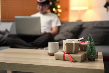 Noel hediyesi kutuları ve bir fincan kahve oturma odasındaki ahşap masada..