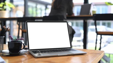 Bilgisayar laptopunu beyaz ekran ve kahve fincanı ile ahşap masaya yapıştır..