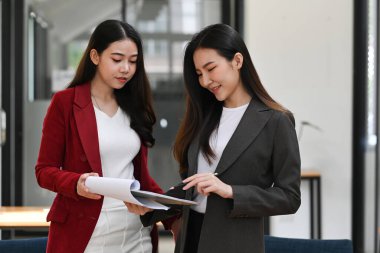 İki kendine güvenen iş kadını fikirleri paylaşıyor ve proje üzerinde birlikte çalışıyorlar..