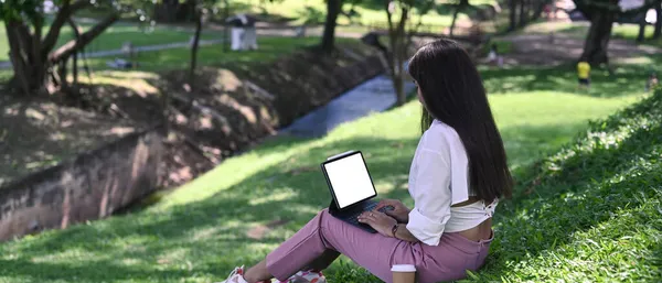 Yeşil Çimlerin Üzerinde Parkta Oturan Bilgisayar Tabletiyle Çalışan Huzurlu Genç — Stok fotoğraf