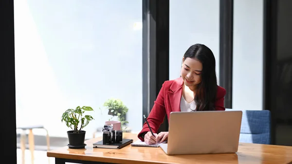 若い女性起業家は 現代の職場に座って ラップトップコンピュータで作業します — ストック写真