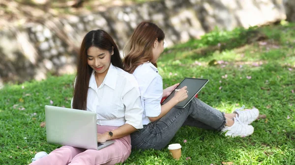 Duas Jovens Sentadas Parque Público Trabalhando Com Laptop Computador — Fotografia de Stock
