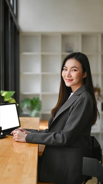 コンピュータのラップトップを使用して魅力的なビジネス女性とカメラに笑みを浮かべて — ストック写真