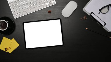 Üst görünüm dijital tablet, pano, yapışkan notlar ve siyah tahta masada bir fincan kahve..