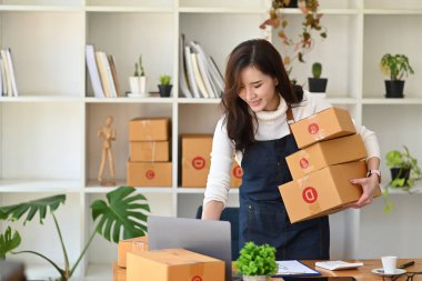 Gülümseyen küçük işletme girişimcisi bilgisayar laptopu kullanarak müşteriden emir alır.