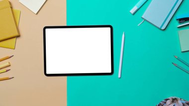 Düz yatılı dijital tablet, stil kalem ve renkli arkaplan kırtasiyesi.