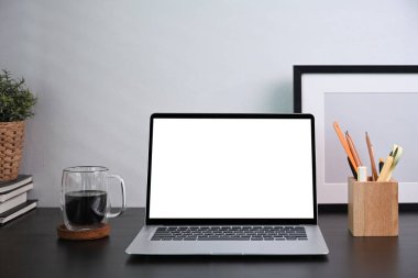 Boş ekran, kalem tutacağı ve ahşap masadaki resim çerçevesi ile ön görünüm bilgisayar dizüstü bilgisayarı.