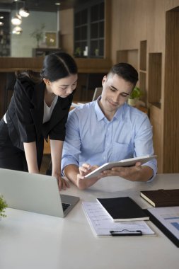 Dijital tablet ve iş planlarını meslektaşıyla paylaşan kendine güvenen bir işadamı..