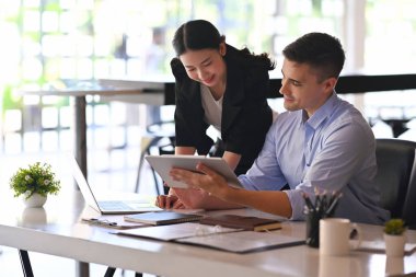 Gülümseyen işadamı elinde dijital tablet ve bilgi kırparak meslektaşına.