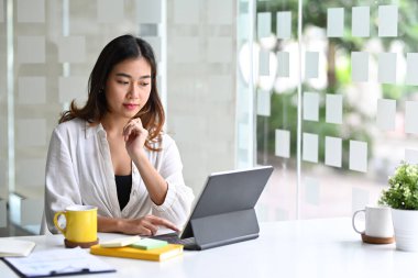 Bilgisayar tabletinde çalışan Asyalı kadın ofis çalışanı.