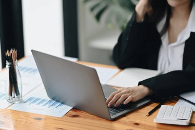 Ofis masasında dizüstü bilgisayarla çalışan vurulan kadın muhasebeci..