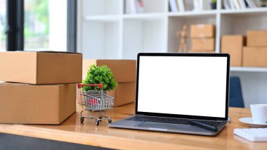 Laptop bilgisayarı, tramvay ve tahta masadaki karton kutular. Çevrimiçi alışveriş veya ekommmerce kavramı.