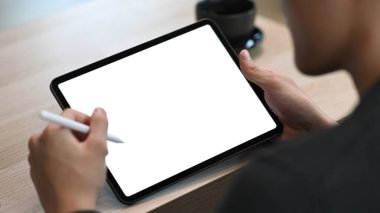 Stylus kalem tutan ve dijital tabletle çalışan işadamının omzunun üstünden bak. 
