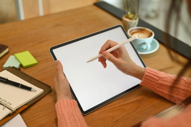 Yakından bakınca, elinde kalem tutan ve dijital tabletle çalışan genç bir kadın görülüyor..