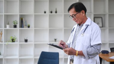 Hasta teşhisini analiz eden ya da hastanede rapor veren uzman bir doktor..