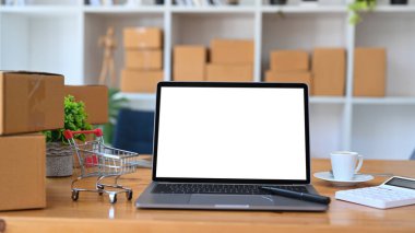 Dizüstü bilgisayarı, tramvayı ve karton kutuları ahşap masaya koyun. Çevrimiçi alışveriş kavramı.