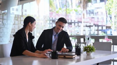 Mutlu iş arkadaşları modern ofiste proje stratejisini tartışıyor..