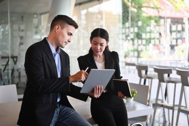 İki iş arkadaşı ofiste yeni başlatılan projeyi tartışıyor.