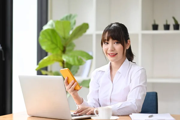 Atrakcyjna Bizneswoman Posiadająca Smartfon Pracująca Laptopem — Zdjęcie stockowe