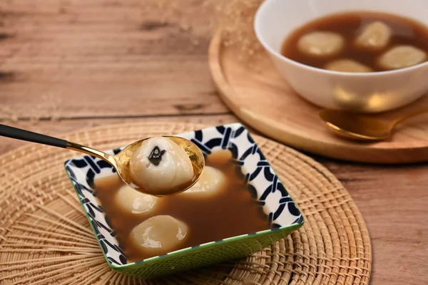 美味的甜饺子和甜姜汤放在木桌上 — 图库照片