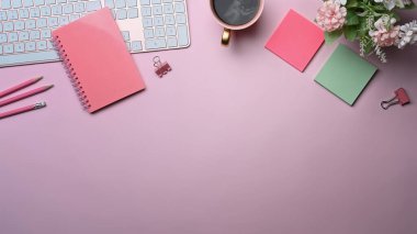 Not defteri, kahve fincanı ve pembe arka planda yapışkan notları olan kadın işyeri.
