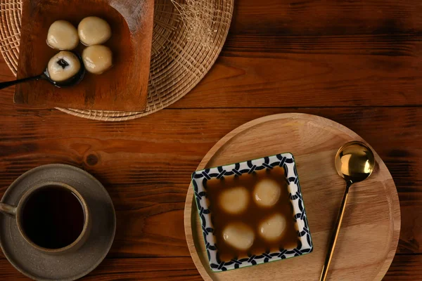 Zencefilli çorbayla ahşap masada siyah susamlı hamur tatlısı..