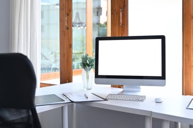 Comfortable workplace with computer, houseplant and office chair.