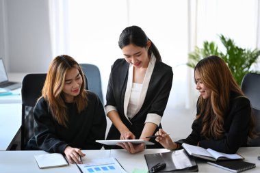 Modern ofiste proje üzerinde çalışan üç iş arkadaşı.
