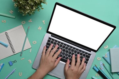 Laptop bilgisayarında yazı yazan öğrenci elleri.