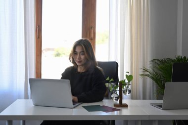 Bilgisayarla çalışan Asyalı iş kadını.