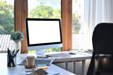 Mock up computer with empty display on white table in modern office.