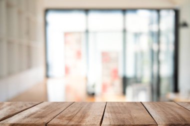 Wooden table with blurred background of coffee shop. For your product display montage.