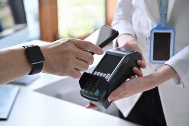 Akıllı telefonu tutan müşteriyi kapat ve dijital ödeme taraması yap.