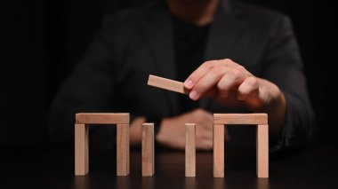 İşadamı tahta blok yerleştiriyor. İş stratejisi ve geliştirme kavramı.