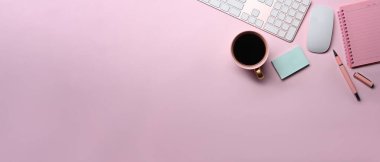 Female workspace with coffee cup, sticky note and notebook on pink background.